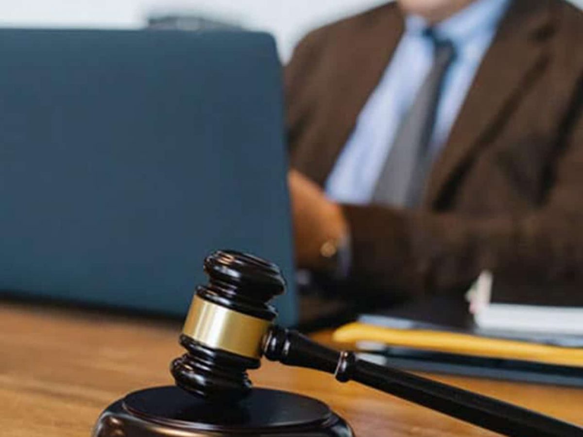 Wooden Gavel With Attorney Using Laptop — McVittie Legal In Alstonville, NSW